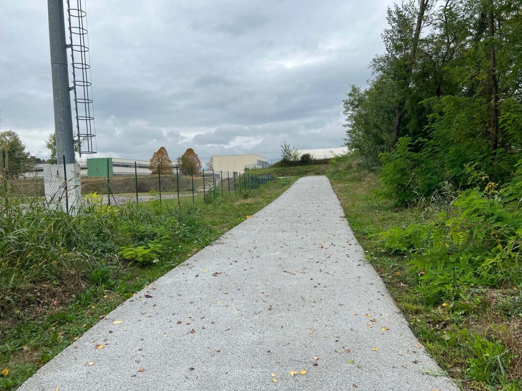 Percorso pedonale integrato in un’area verde riqualificata, priva di barriere.